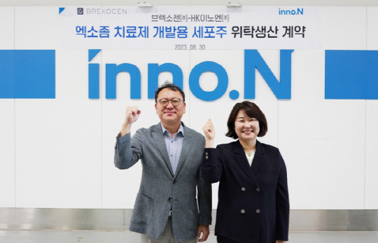 원성용 HK이노엔 바이오연구소장과 김수 브렉소젠 대표가 위탁생산 계약을 체결한 뒤 사진촬영을 하고 있다. HK이노엔 제공.